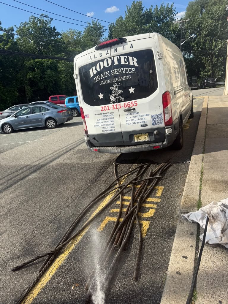 The van parked at the kerb with cable run out along the road surface to the line.