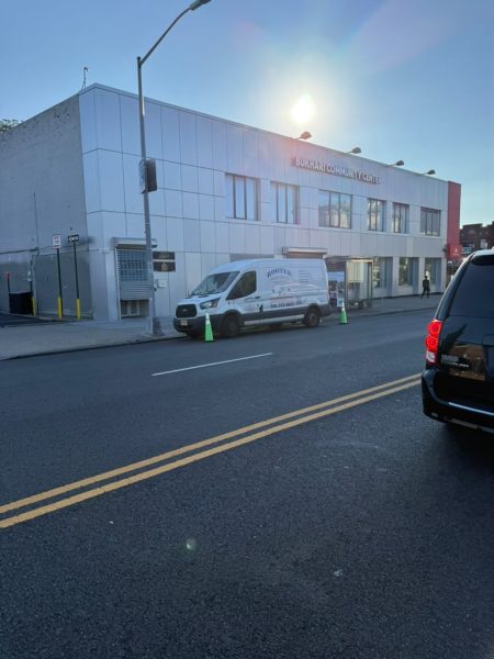 The van parked at the kerb outside a commercial building at dusk.
