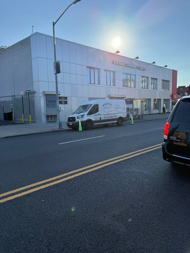 The van parked at the kerb outside a commercial building at dusk.